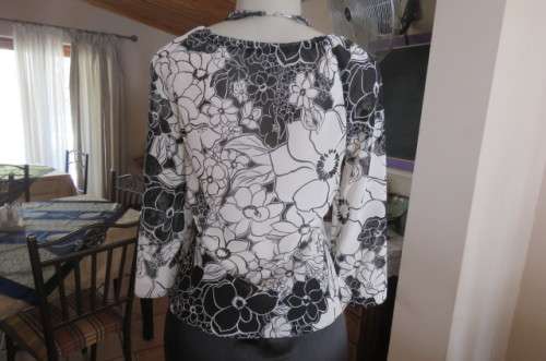 Black and white top with bold floral pattern With raglan sleeves in bracelet length Size 32/8.As new