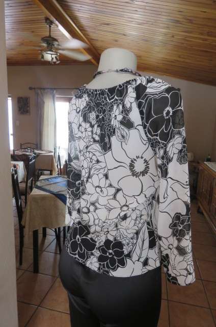 Black and white top with bold floral pattern With raglan sleeves in bracelet length Size 32/8.As new