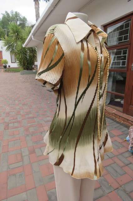 Unique permanent pleated short sleeve top in size 44/20. Button down front with shirt collar.