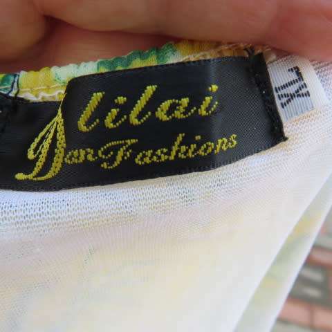 Sheer polyester peplum style top in yellow with pink and green shell designs. Size 38/14.