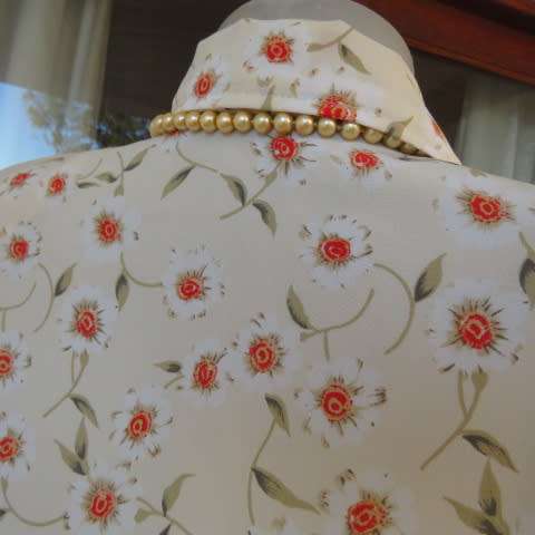 Boutique made cream short sleeve top with white/orange daisies. Button down. Size 44/20.As new