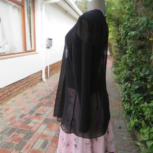 Waterfall style sheer black long sleeve top with V front size 38/14. In 100% polyester fabric.