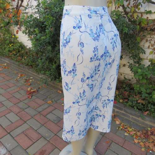 Pencil skirt in light blue with darker floral pattern. Size 32/8 by 'Sensations'. In 100% polyester.