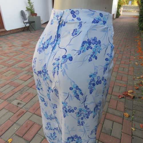 Pencil skirt in light blue with darker floral pattern. Size 32/8 by 'Sensations'. In 100% polyester.