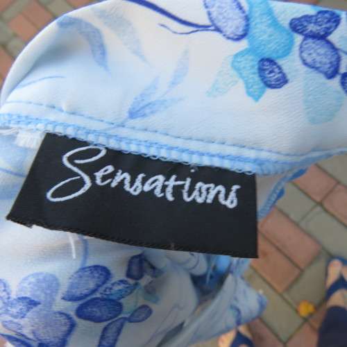 Pencil skirt in light blue with darker floral pattern. Size 32/8 by 'Sensations'. In 100% polyester.