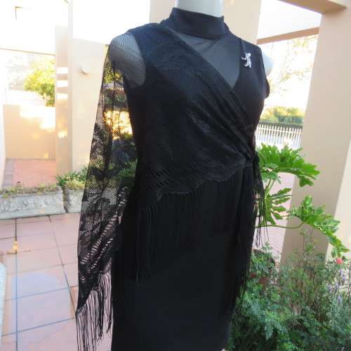 Black triagle throw 150cm x 115cm x 115cm. Floral pattern on mesh look with fringed borders.