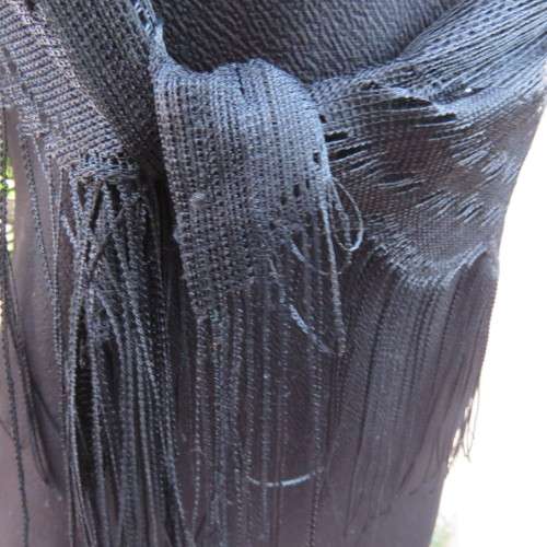 Black triagle throw 150cm x 115cm x 115cm. Floral pattern on mesh look with fringed borders.