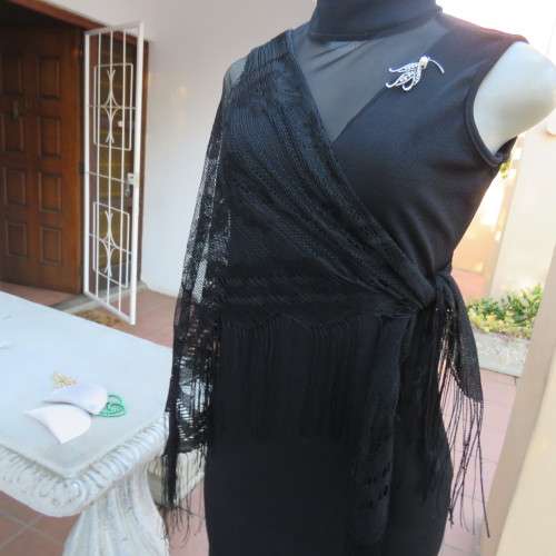 Black triagle throw 150cm x 115cm x 115cm. Floral pattern on mesh look with fringed borders.