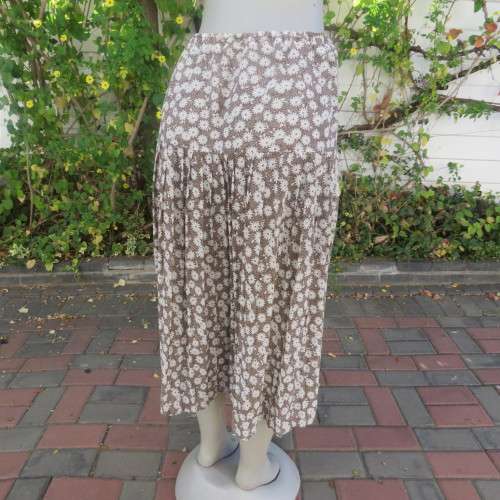 Fabulous light weight skirt in light brown with white daisies. Wide yoke with knife pleats. Size 46