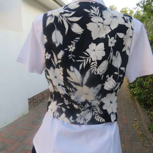 Smashing new navy and white floral fully lined waistcoat by ELBETH in size 36/12. Button down.