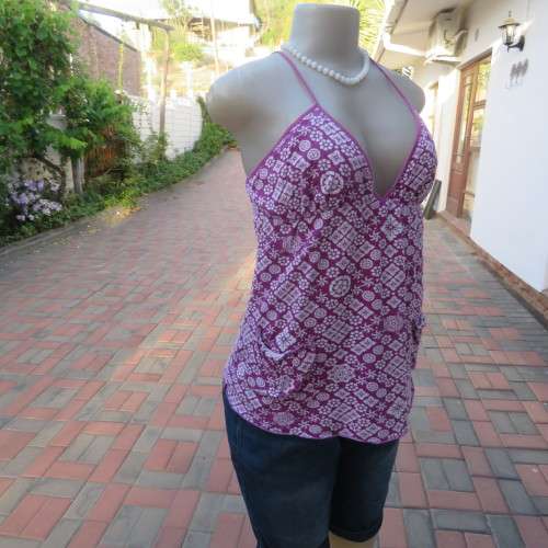 As new`Billabong`strappy top in size 38/14. In violet and white floral pattern.Unique strappy detail
