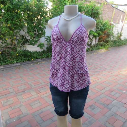 As new`Billabong`strappy top in size 38/14. In violet and white floral pattern.Unique strappy detail