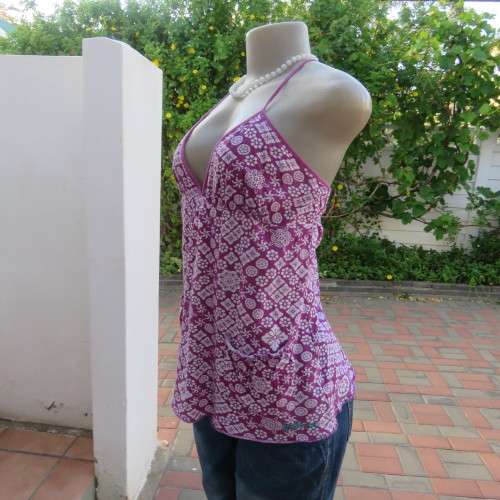 As new`Billabong`strappy top in size 38/14. In violet and white floral pattern.Unique strappy detail