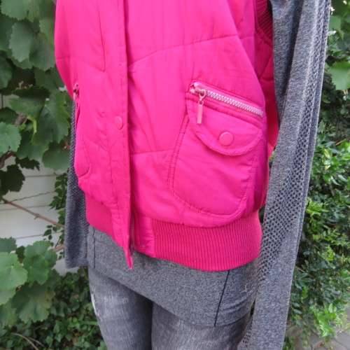 Warm magenta pink padded zip up waistcoat in size 36/12. Front pockets. Knitted ribbings.