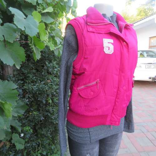 Warm magenta pink padded zip up waistcoat in size 36/12. Front pockets. Knitted ribbings.