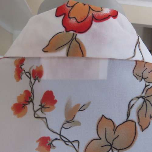Make a statement in this cheerful white polyester top with bright autumn colour flowers..Size 44/20