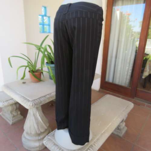 Elegant black straight legged pants with thin white vertical stripes.Low rise. Size 38/14. By W.W.W.