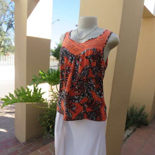 Cute colourful sleeveless top in orange with black/white leaves.Orange lace front decoration Size 36