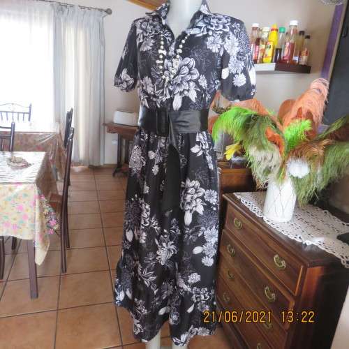 Pretty black and white floral 100% polyester dress with short sleeves.By OR size 34/10.Belt included