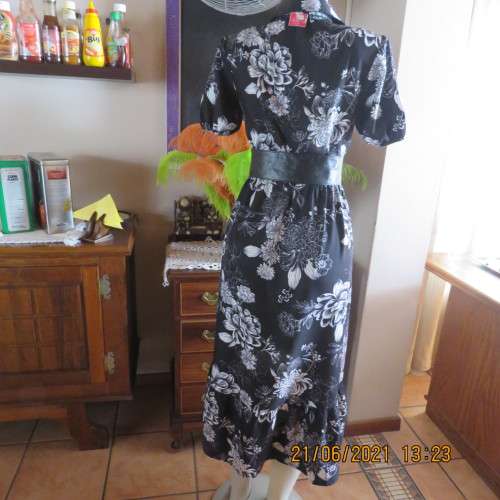 Pretty black and white floral 100% polyester dress with short sleeves.By OR size 34/10.Belt included