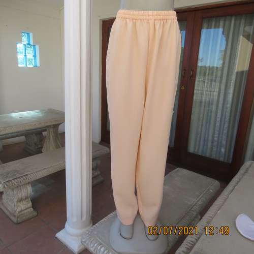 Fresh,easy to wear peach colour pants with tapered legs in 100% crepe polyester. Size 42 to 44