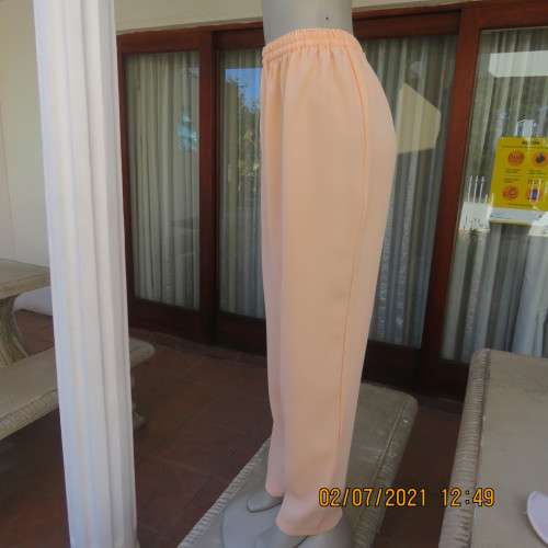 Fresh,easy to wear peach colour pants with tapered legs in 100% crepe polyester. Size 42 to 44