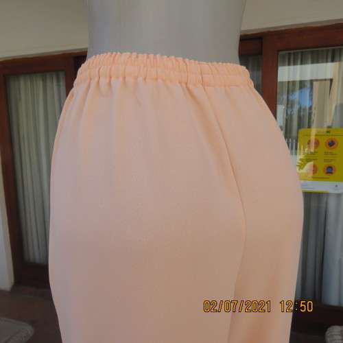 Fresh,easy to wear peach colour pants with tapered legs in 100% crepe polyester. Size 42 to 44