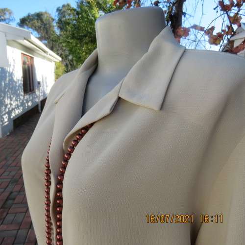 Stylish rich cream button down top in textured polyester.With flare sleeve cuffs. Size 42/18. As new