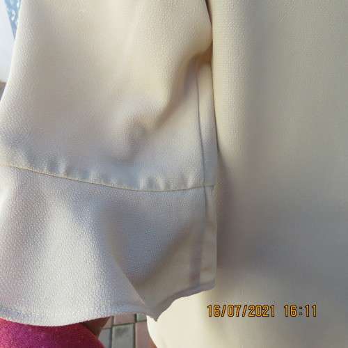 Stylish rich cream button down top in textured polyester.With flare sleeve cuffs. Size 42/18. As new
