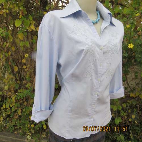 High quality powder blue button down top with tasteful floral front embroidery. Size 38 to 40.By M H