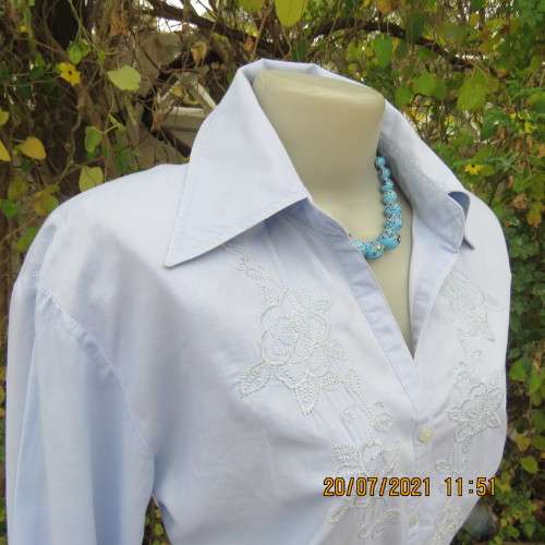 High quality powder blue button down top with tasteful floral front embroidery. Size 38 to 40.By M H
