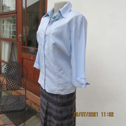 High quality powder blue button down top with tasteful floral front embroidery. Size 38 to 40.By M H