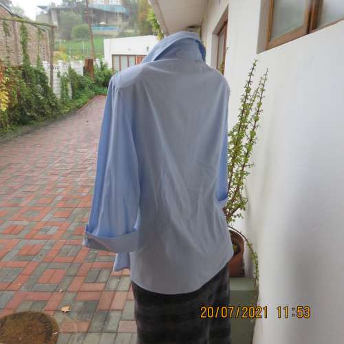 High quality powder blue button down top with tasteful floral front embroidery. Size 38 to 40.By M H