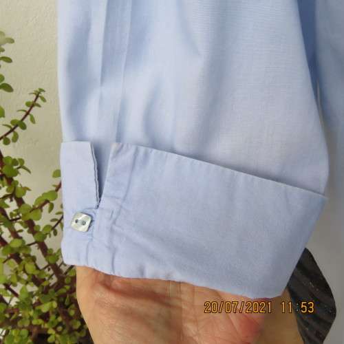 High quality powder blue button down top with tasteful floral front embroidery. Size 38 to 40.By M H