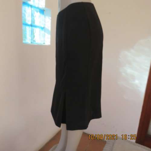 High quality as new black FINNEGANS skirt in size 34/10. Bandless.In 7 panels with 2 inverted pleats