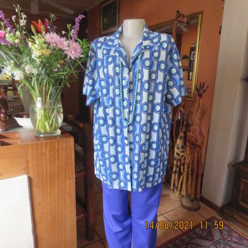 Geometric printed short sleeve top in blue shades with green accents. By DAVLEY size 46/22.As new
