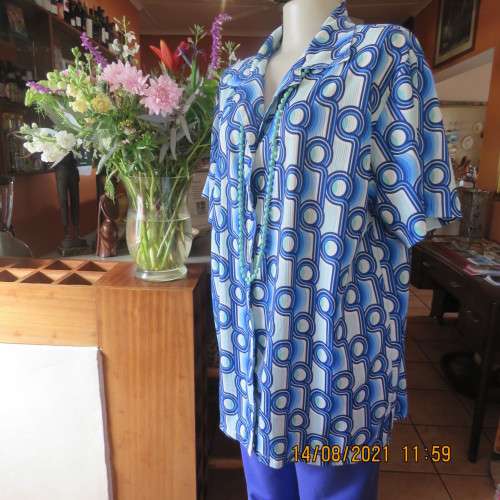 Geometric printed short sleeve top in blue shades with green accents. By DAVLEY size 46/22.As new