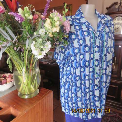Geometric printed short sleeve top in blue shades with green accents. By DAVLEY size 46/22.As new