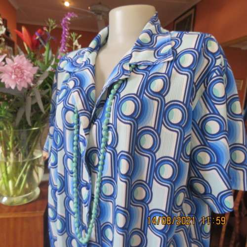 Geometric printed short sleeve top in blue shades with green accents. By DAVLEY size 46/22.As new