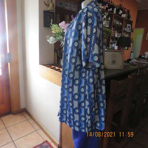 Geometric printed short sleeve top in blue shades with green accents. By DAVLEY size 46/22.As new