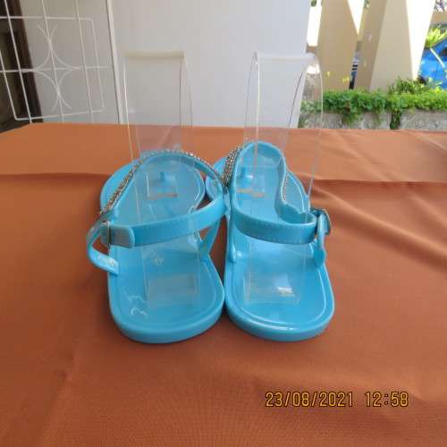 Pair of blue plastic sandals in size 7. Strap between toes and around ankle.Faux diamond decoration.