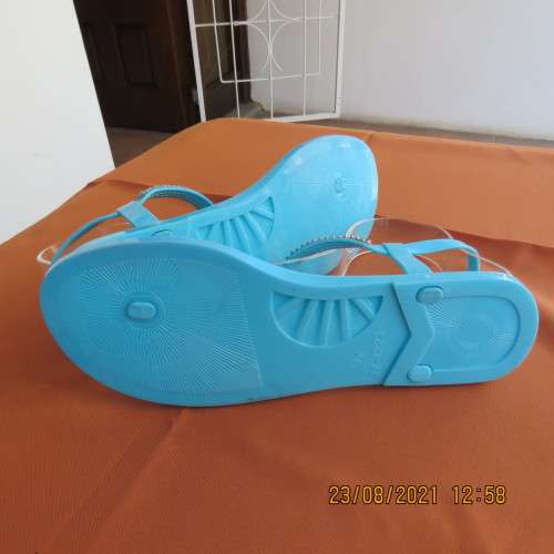 Pair of blue plastic sandals in size 7. Strap between toes and around ankle.Faux diamond decoration.
