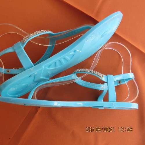 Pair of blue plastic sandals in size 7. Strap between toes and around ankle.Faux diamond decoration.