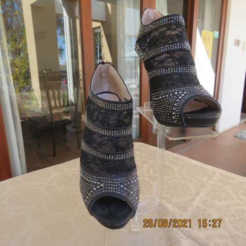 Pair of shiny black ankle summer boots with lace and studs. Stiletto heels.Open toes.By ORBIT size 7