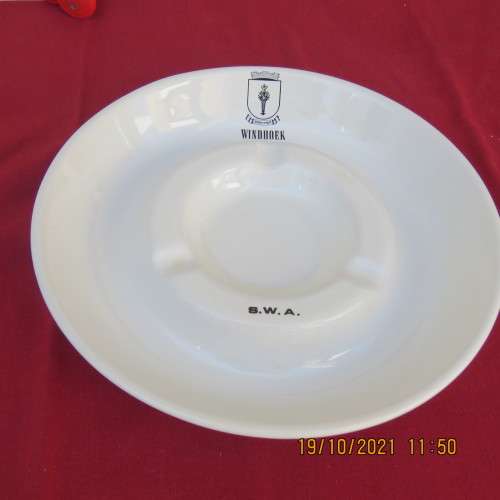 As new vintage large white porcelain ashtray from Windhoek S W A with badge.21cm diameter.About 30yr