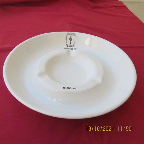 As new vintage large white porcelain ashtray from Windhoek S W A with badge.21cm diameter.About 30yr