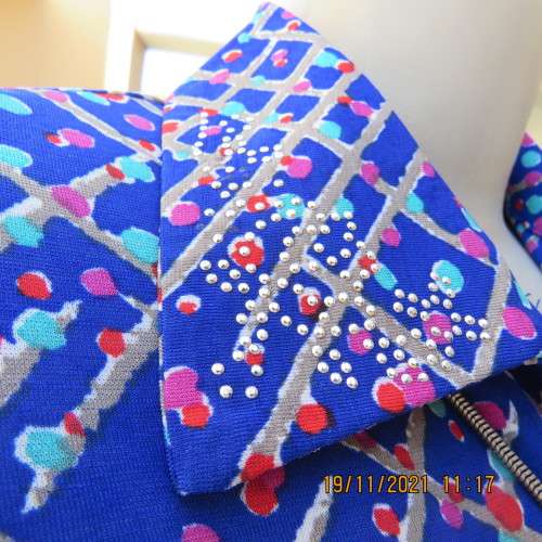 New blue patternened slip over stretch polyester top. Short front zip and embellished collar.Size 36