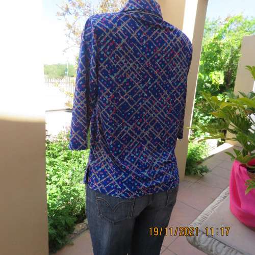 New blue patternened slip over stretch polyester top. Short front zip and embellished collar.Size 36
