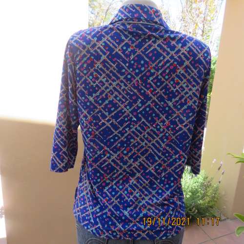 New blue patternened slip over stretch polyester top. Short front zip and embellished collar.Size 36