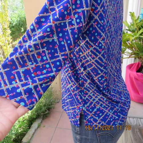 New blue patternened slip over stretch polyester top. Short front zip and embellished collar.Size 36